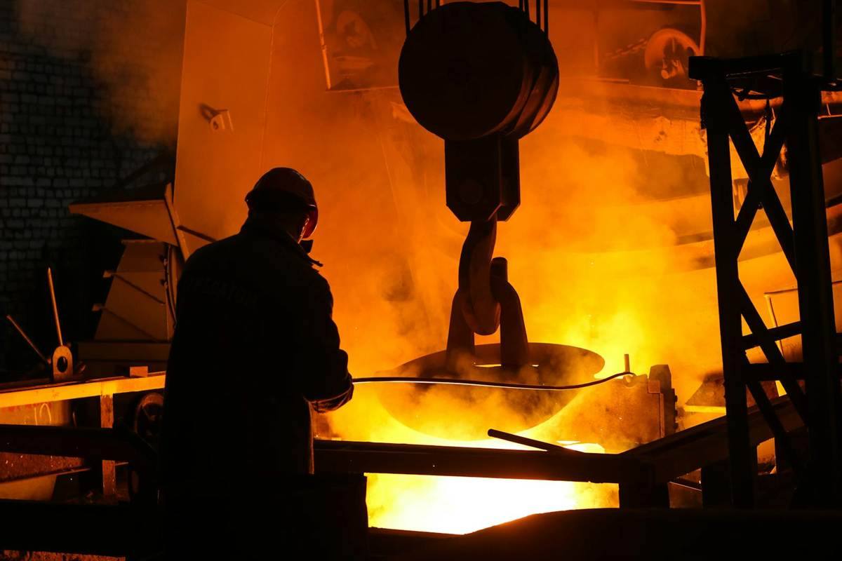 Steel melting shop operator inspecting molten iron process